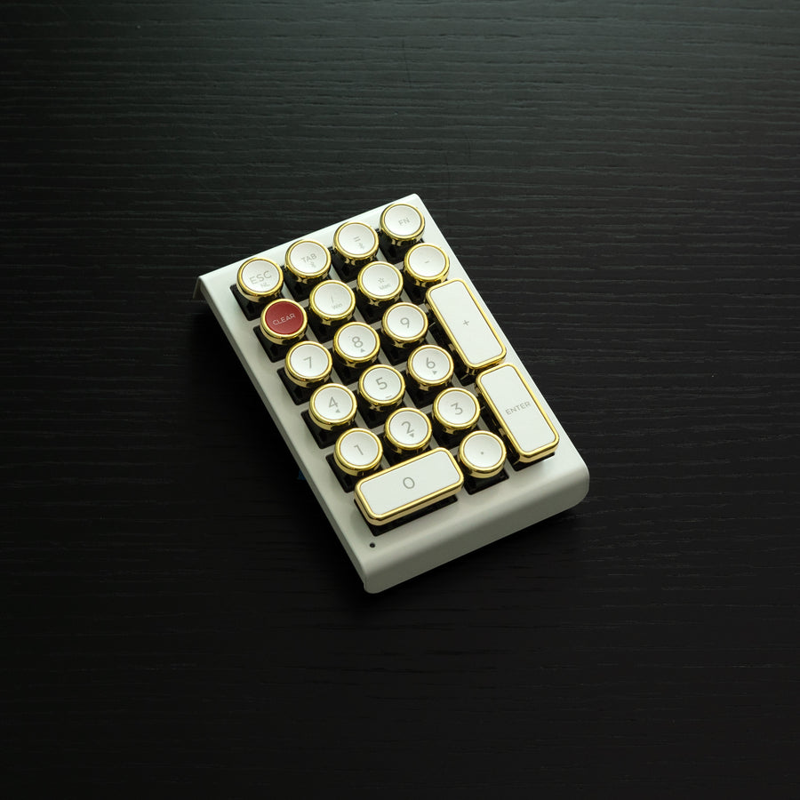 Qwerkywriter typewriter keyboard numkey numpad best in class premium all aluminum body in white gold right side view on black wood grain 